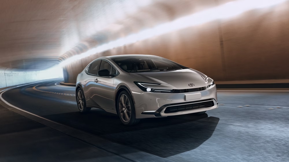 Toyota Prius 2025 argentée roulant dans un tunnel éclairé, avec un design futuriste et aérodynamique mis en valeur par les reflets lumineux.
