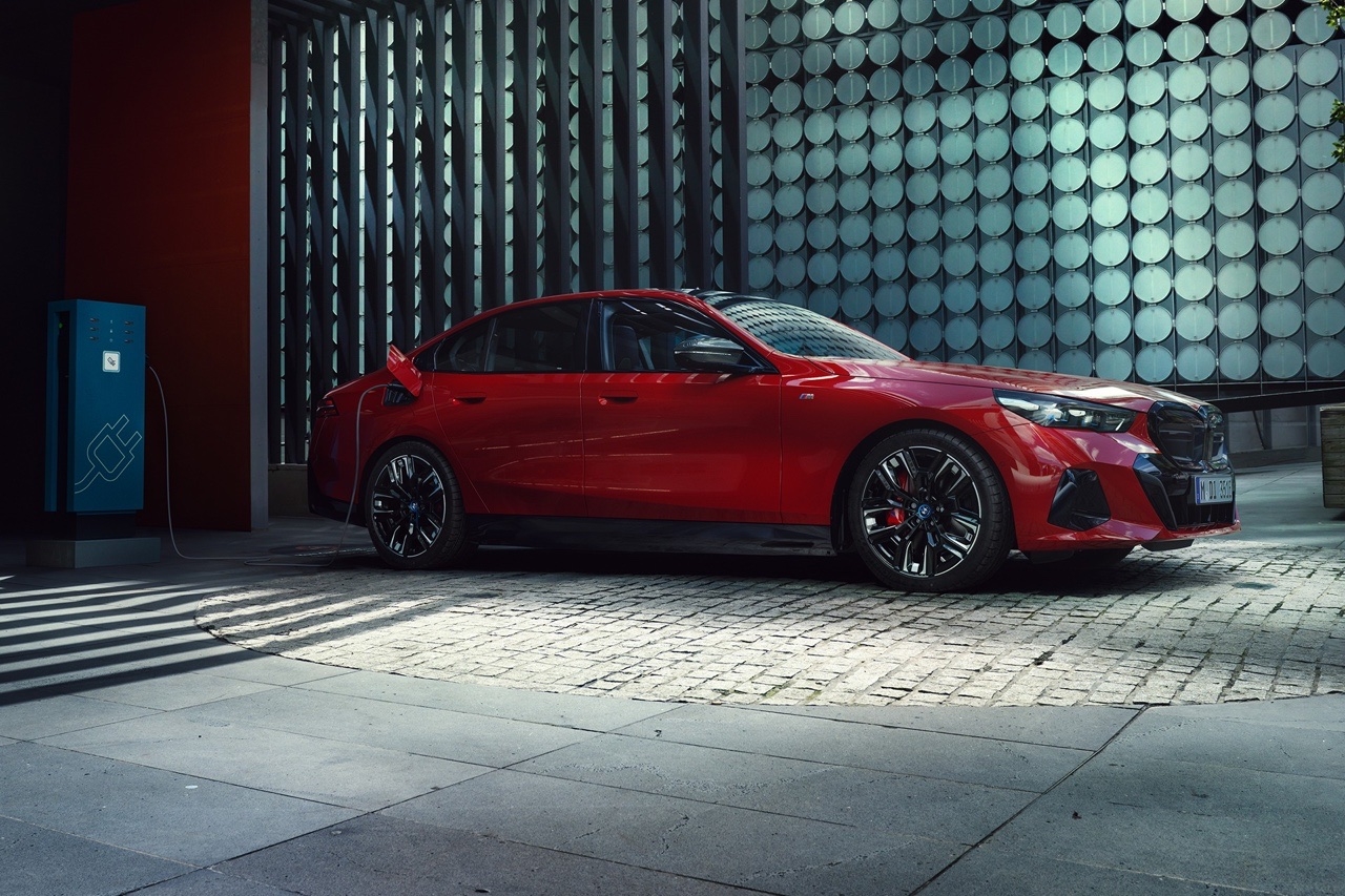 BMW i5 2025 stationnée devant un immeuble moderne, illustrant l’élégance électrique et la prestance d’une berline de luxe.