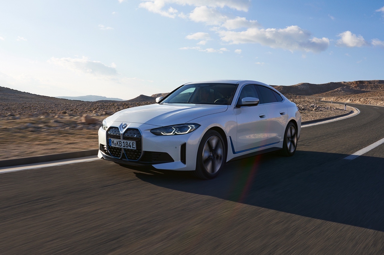 BMW i4 eDrive35 en pleine conduite sur route sinueuse, illustrant sa sportivité et son design épuré.
