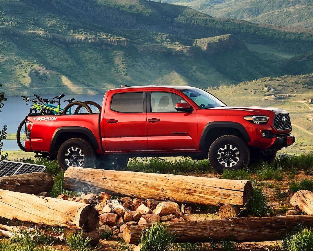 Toyota Tacoma TRD Sport rouge avec vélos, camion fiable d’occasion idéal pour le remorquage et l’aventure.