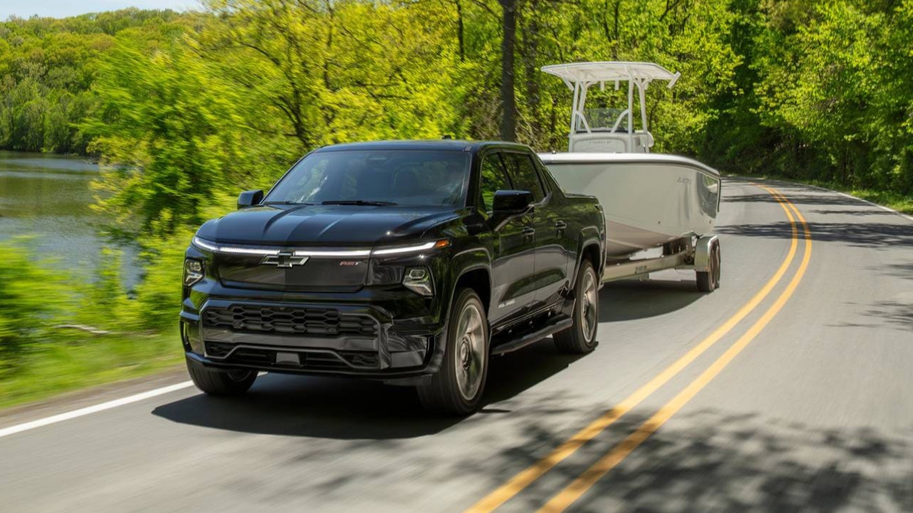 Chevrolet Silverado EV 2025 de profil sur route panoramique, illustrant sa puissance de remorquage et sa modernité embarquée.